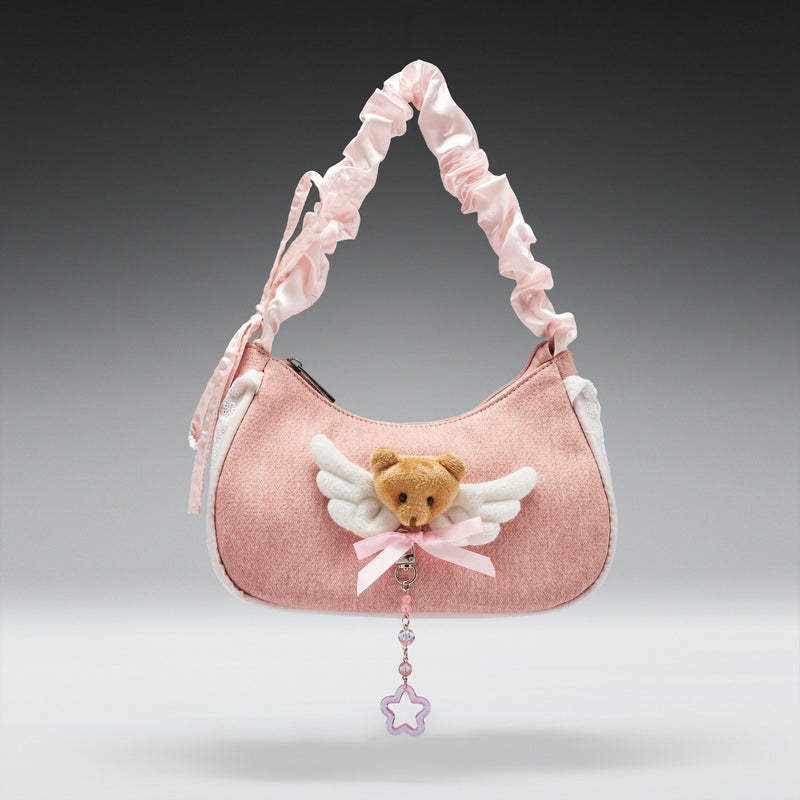 Pink handbag with teddy bear charm on a gray background