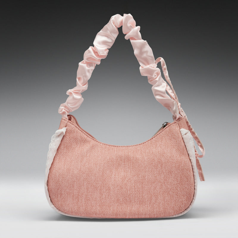 Pink handbag with ruffled handle on a gray background