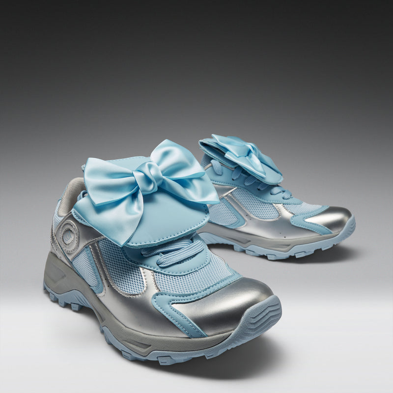 Pair of children's shoes with large bows on a gradient background