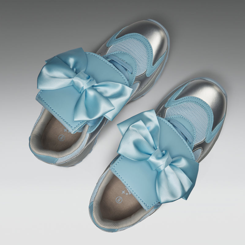 Pair of light blue sandals with large bows on a gradient background