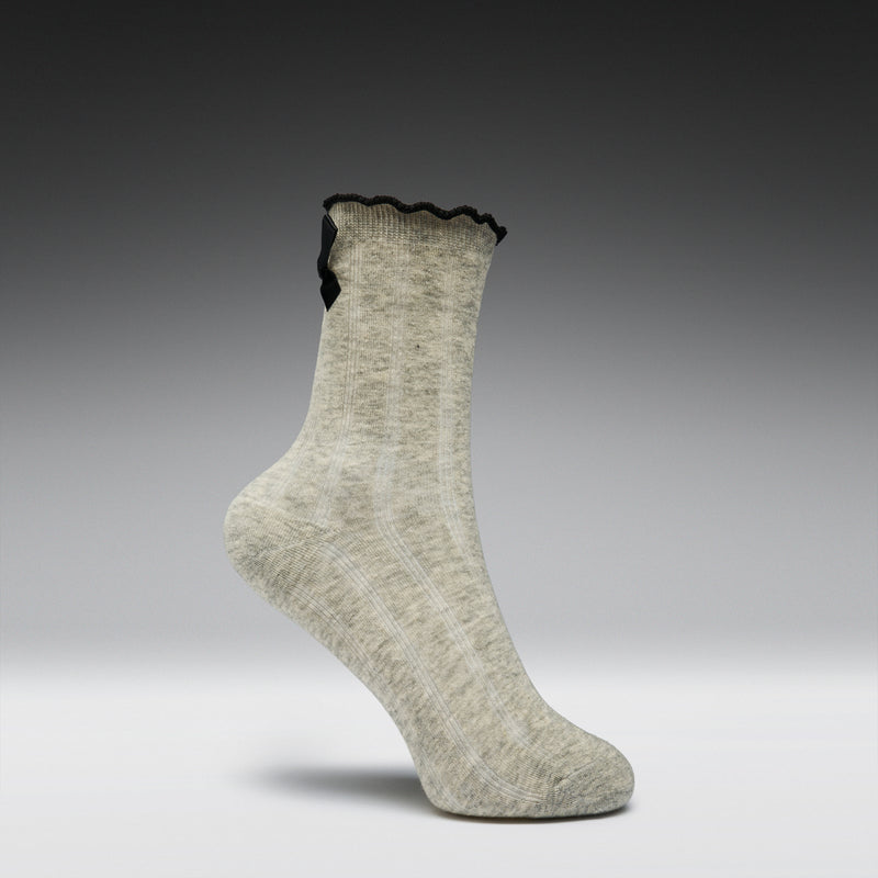 Gray sock with black lace trim on a gray background