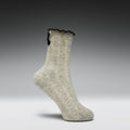 Gray sock with black lace trim on a gray background