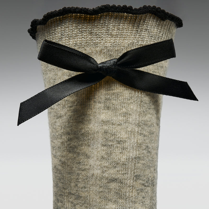 Gray sock with a black bow on a gray background
