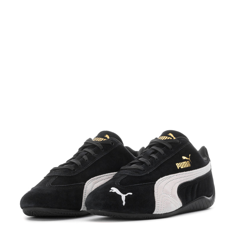 Pair of Puma women's low-top sneakers, black with white Puma logos and lace-up design