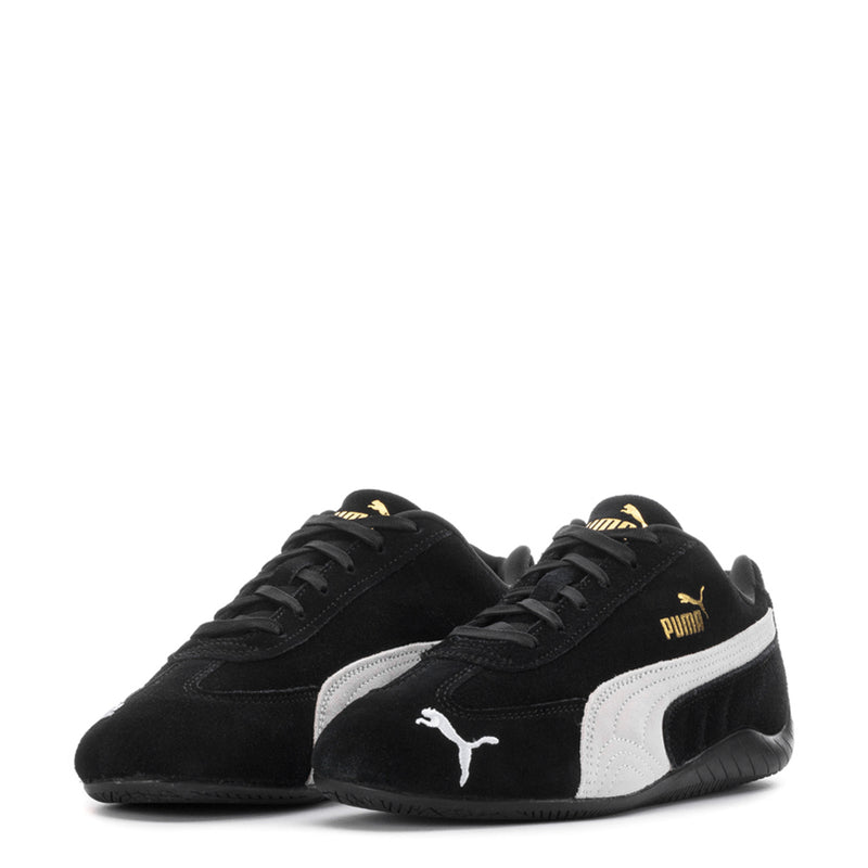 Pair of youth black Puma sneakers with white stripe panel and lace-up front