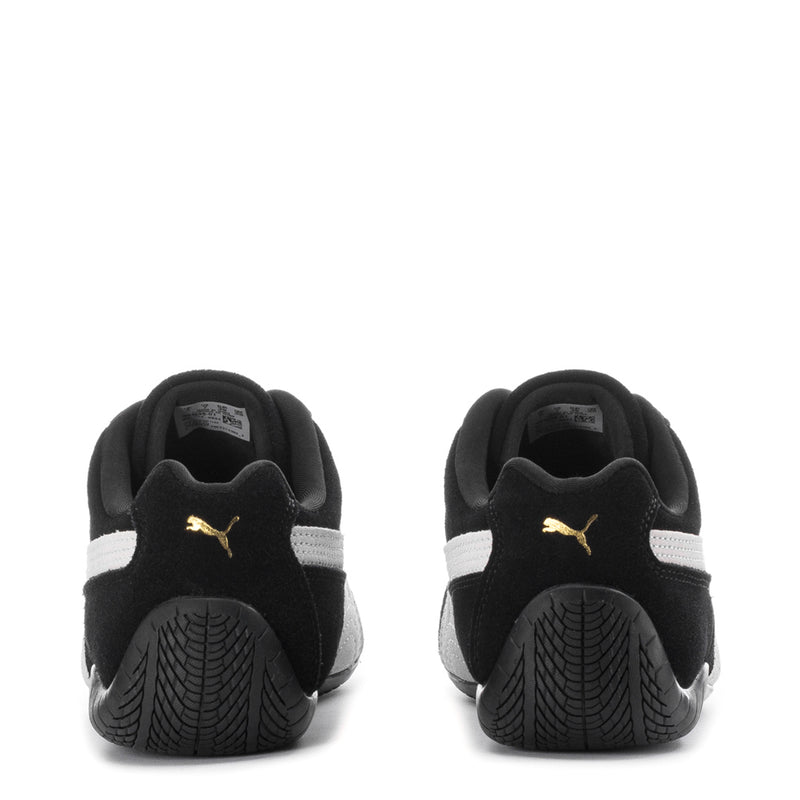 Youth Puma sneakers back view with black uppers, heel pull tab, and Puma logo