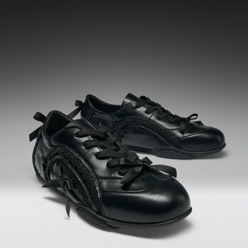Pair of black leather shoes on a gradient gray background