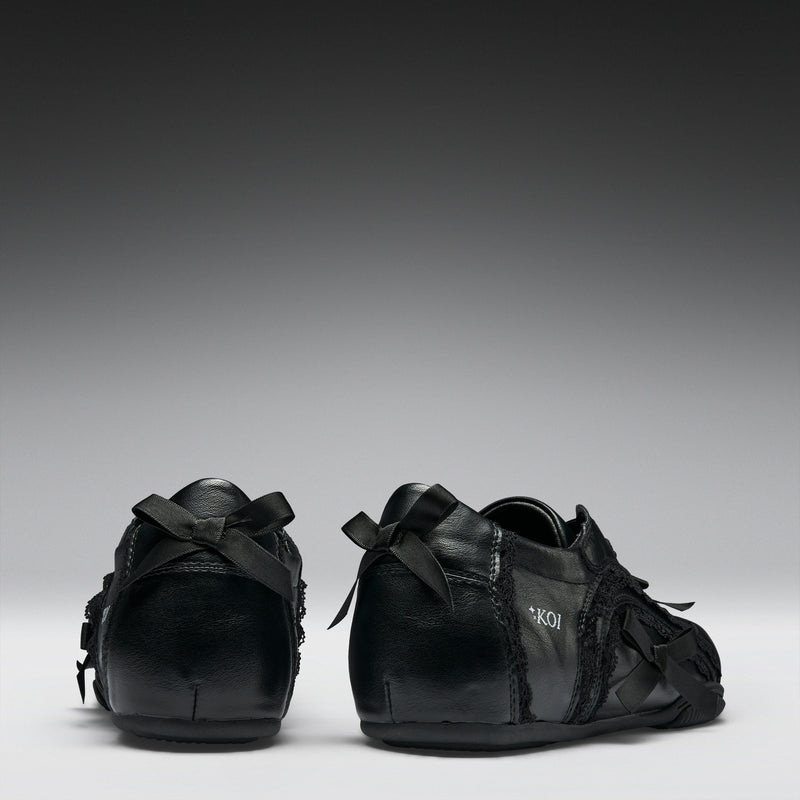 Pair of black leather shoes with laces on a gray background