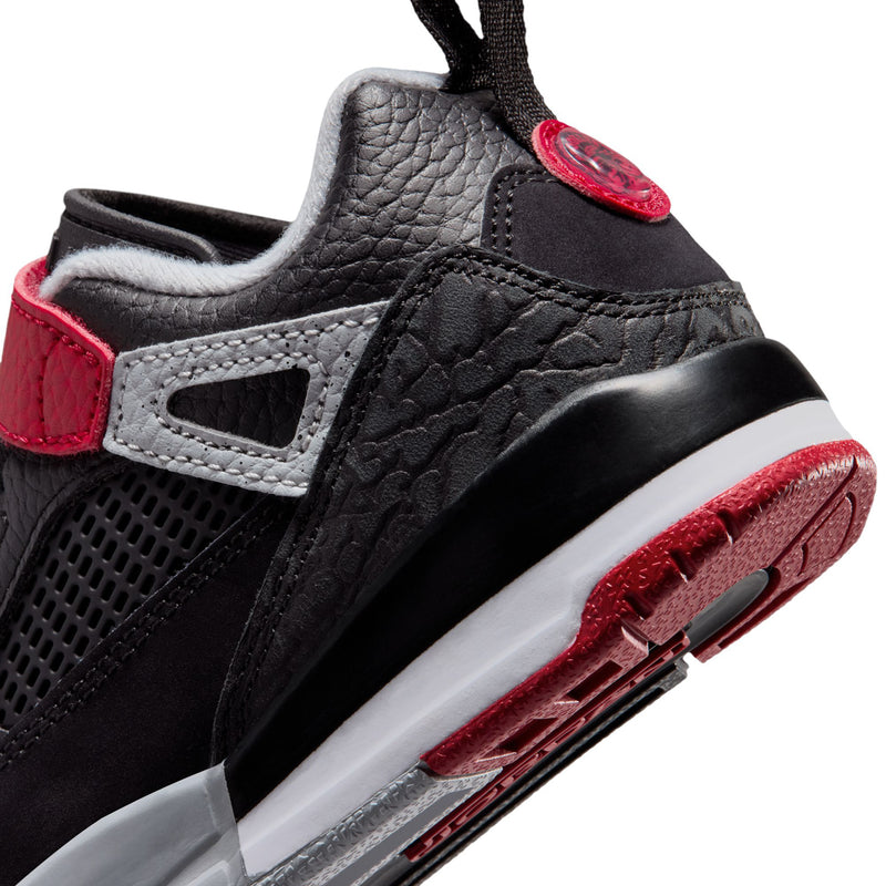 Kids low-top sneaker close-up at side and heel with red trim and white midsole edge