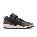 Black low-top sneaker with red lace accents, brown suede panel, white midsole