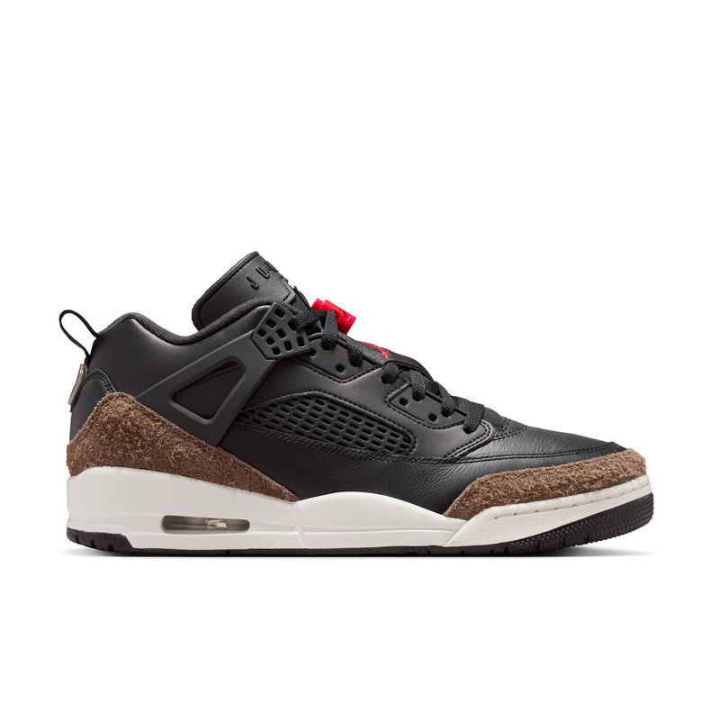 Black low-top sneaker with red lace accents, brown suede panel, white midsole