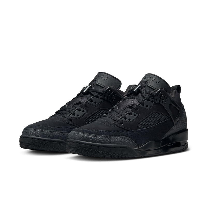 Black low-top sneaker angled view with perforated toe, lace-up, and side strap