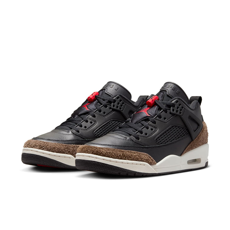 Black low-top sneaker with red lace accents, brown suede underlay, white midsole