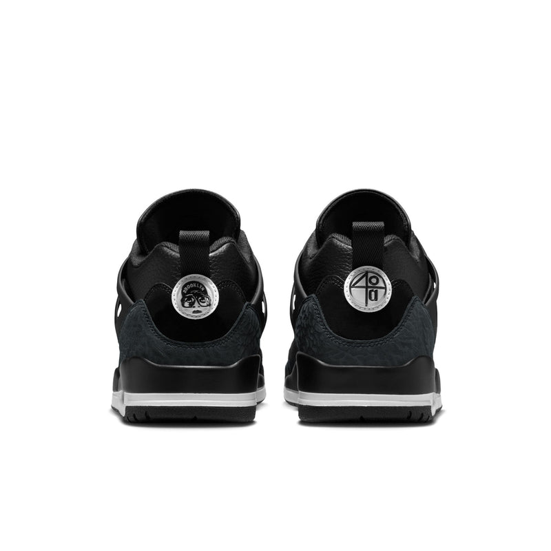 Men's black low-top sneakers back view with heel tabs and white midsole strip.