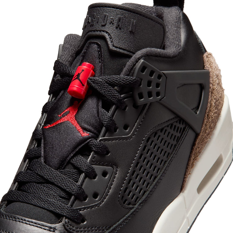 Close-up of black sneaker with red lace tag, red Jumpman emblem, perforated side