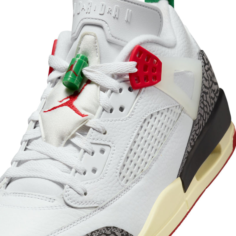 Men’s sneaker upper close-up, white leather with red emblem and green lace detail