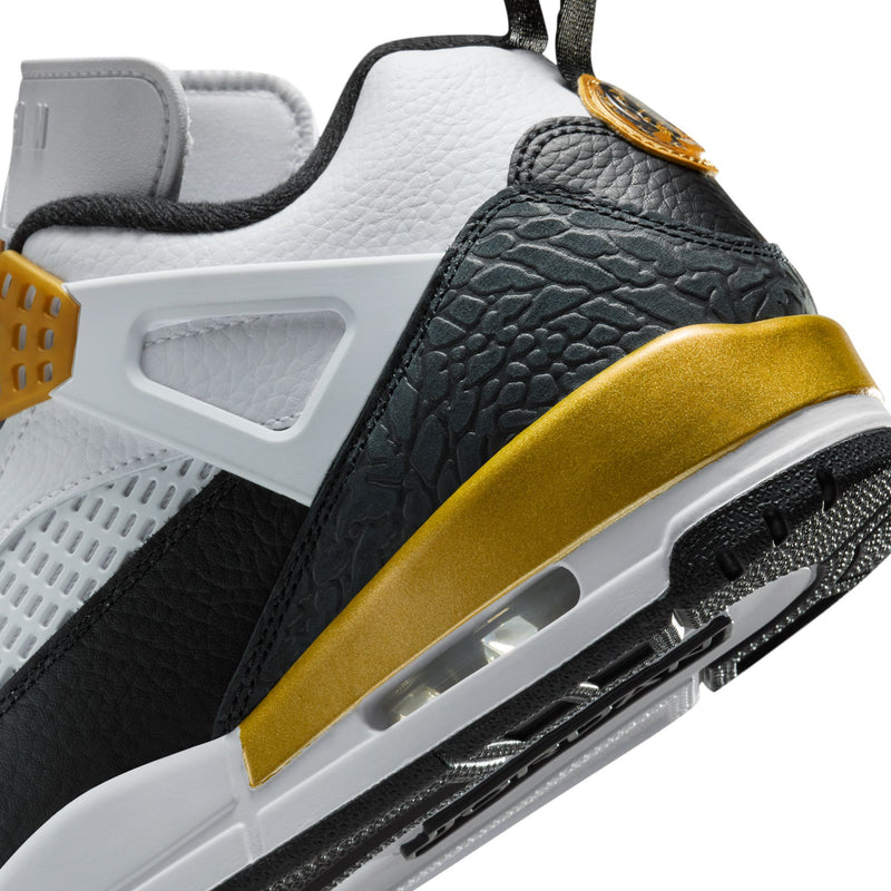 Close-up of men's low-top sneakers: black textured panel with metallic gold stripe and air unit.
