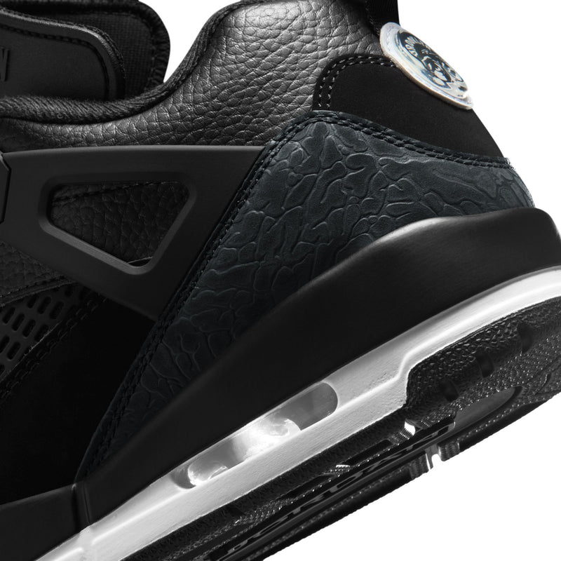Men's black low-top sneakers close-up of side panel texture and silver midsole detail.