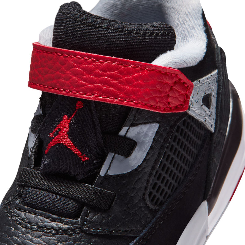 Toddler sneaker side close-up: red strap, black leather, gray panel, Jumpman logo