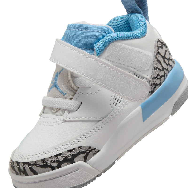 Toddler low-top sneakers close-up; white upper with light blue collar and side leopard panel