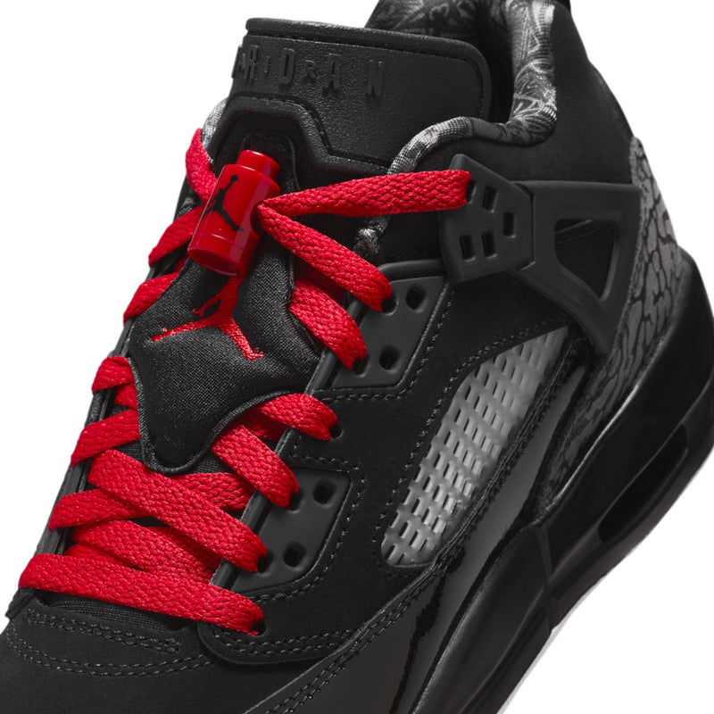 Youth sneaker close-up: black leather with red laces and textured gray side panel