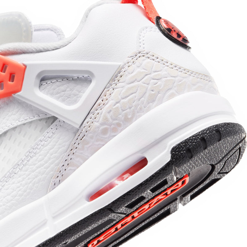 Close-up side view of youth white sneaker with textured panel and crimson branding stripe