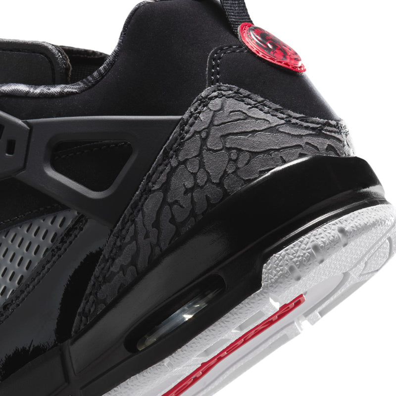 Youth sneaker side view in black with red heel detail and white rubber outsole