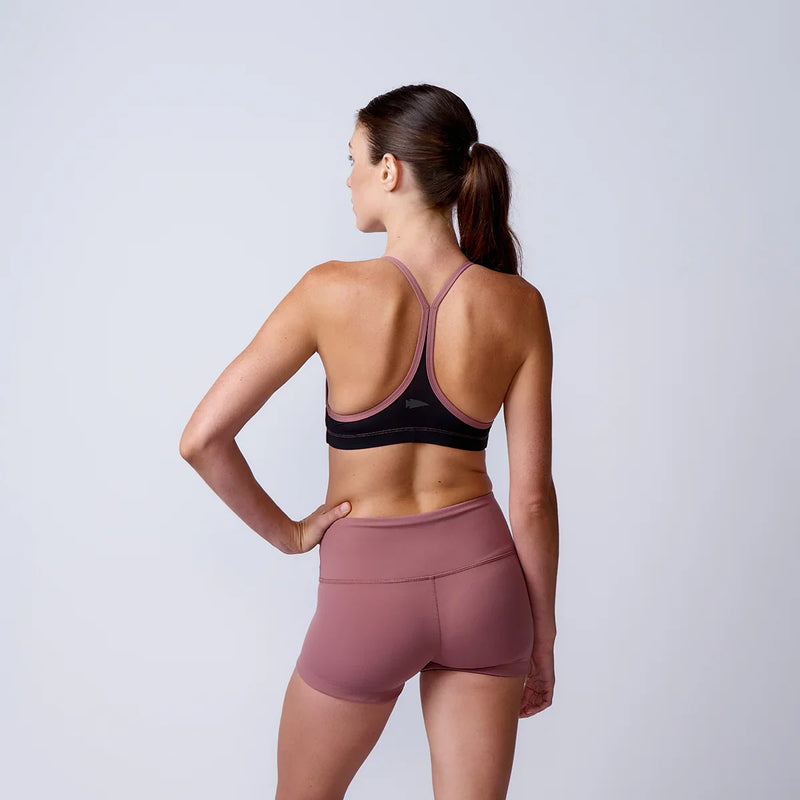Woman modeling GORUCK rucking sports bra and shorts, studio back view, athletic wear