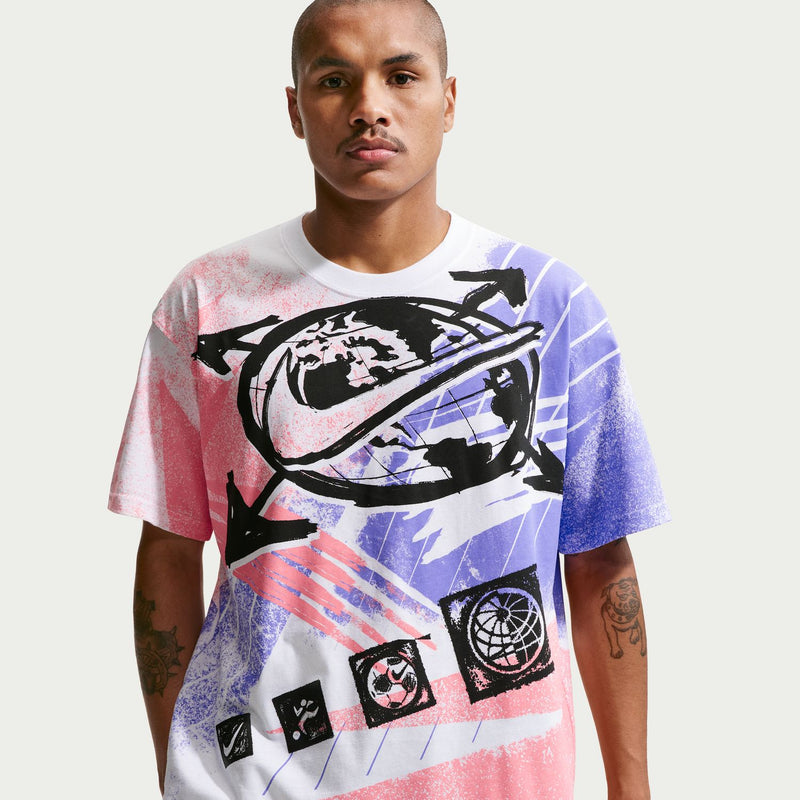 Men's short-sleeve graphic T-shirt worn by model; white base with pink and blue print