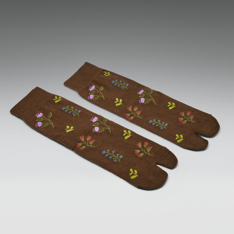 Pair of brown socks with floral patterns on a gray background