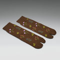 Pair of brown socks with floral patterns on a gray background