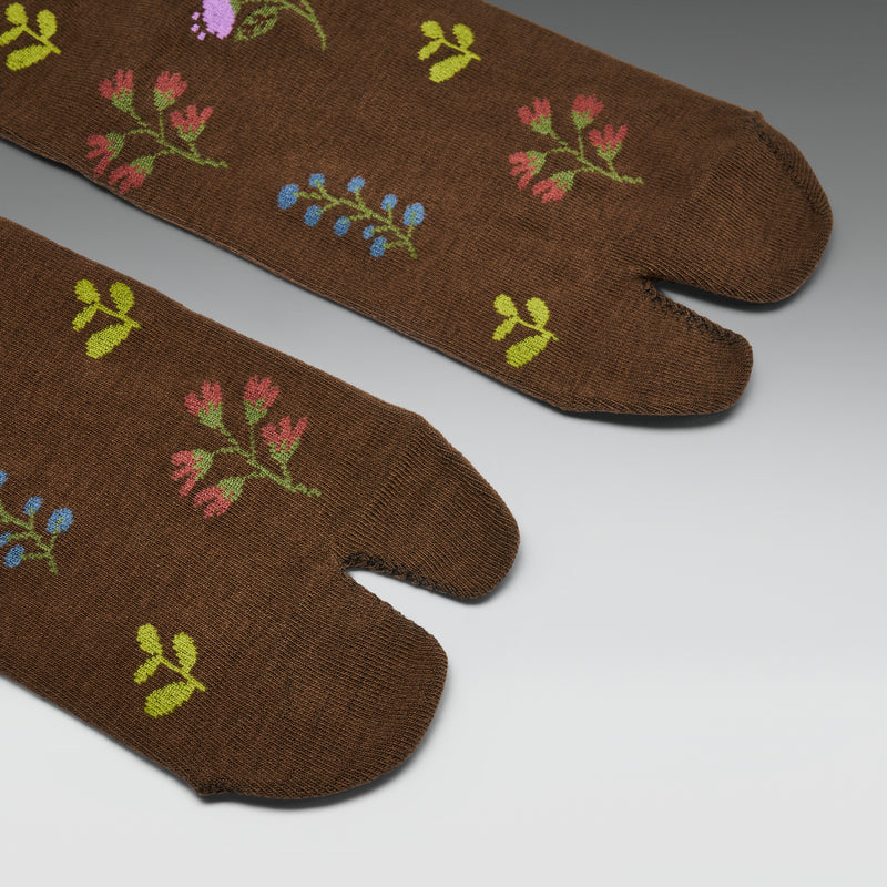 Brown tabi socks with floral patterns on a gray background