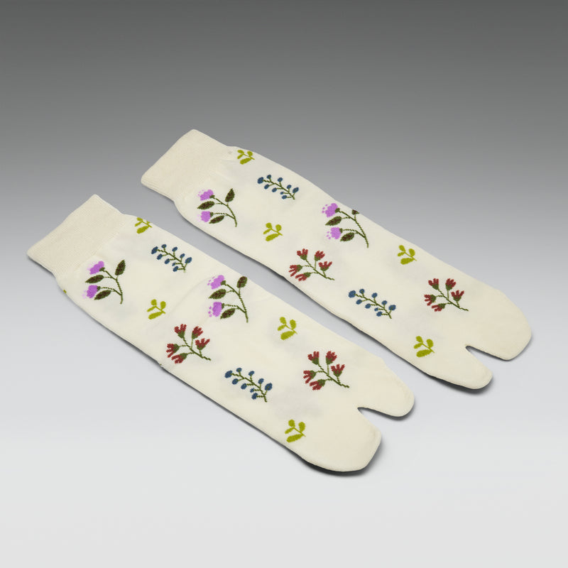 Pair of white tabi socks with floral patterns on a gray background