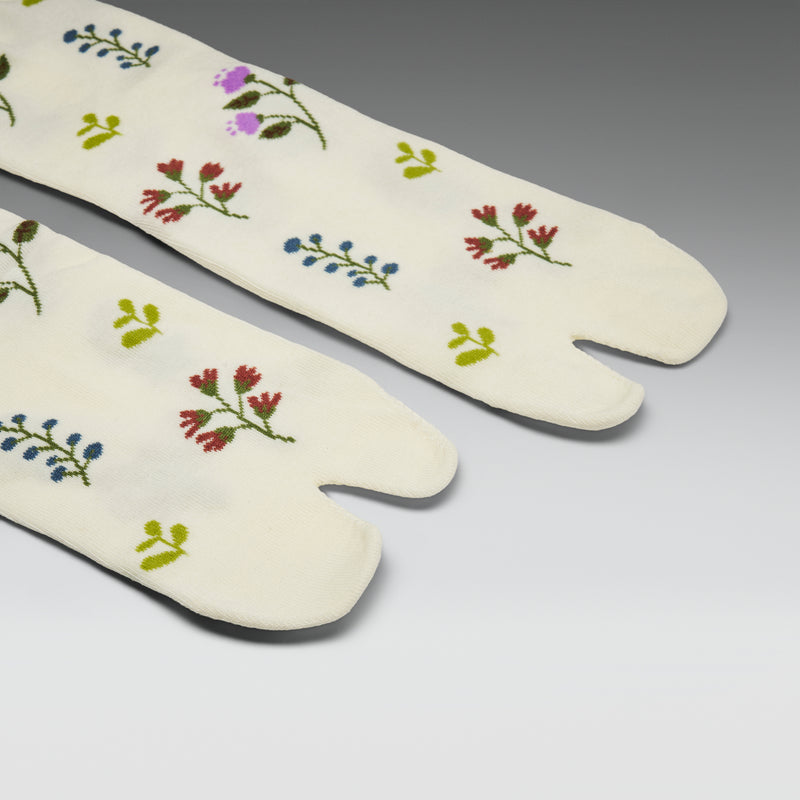 Pair of white tabi socks with floral patterns on a gray background