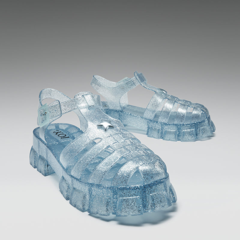 Clear blue jelly sandals on a gray background