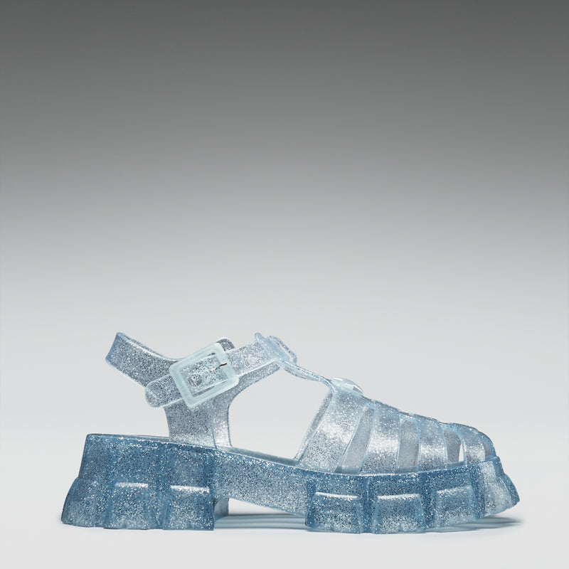 Clear jelly sandal with glittery sole on a gray background