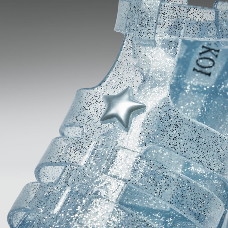 Close-up of a glittery blue sandal with a star detail on a gray background