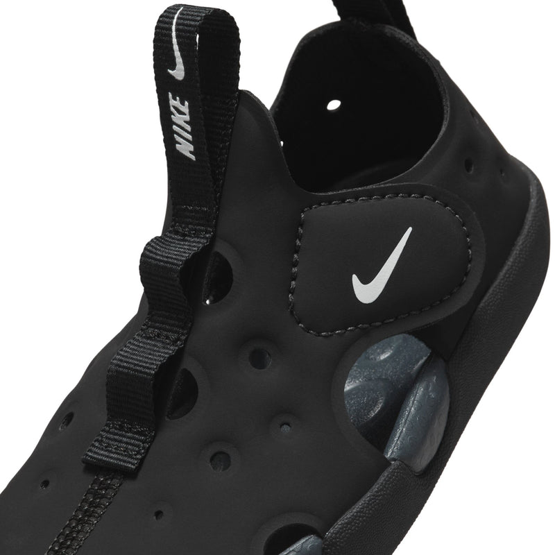 Close-up toddler Nike black sandal showing swoosh, strap, and cushioned footbed