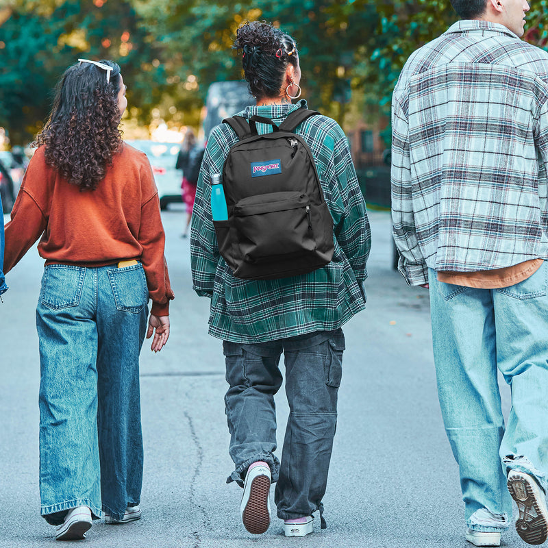 Black JanSport backpack worn by child, street view from behind