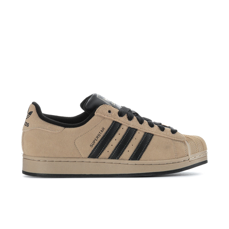 Tan suede lace-up sneakers with black laces and navy three-stripe side