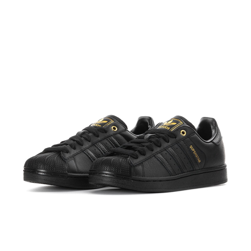 Men's black Adidas sneakers, side view with three gold stripes and lace-up front.