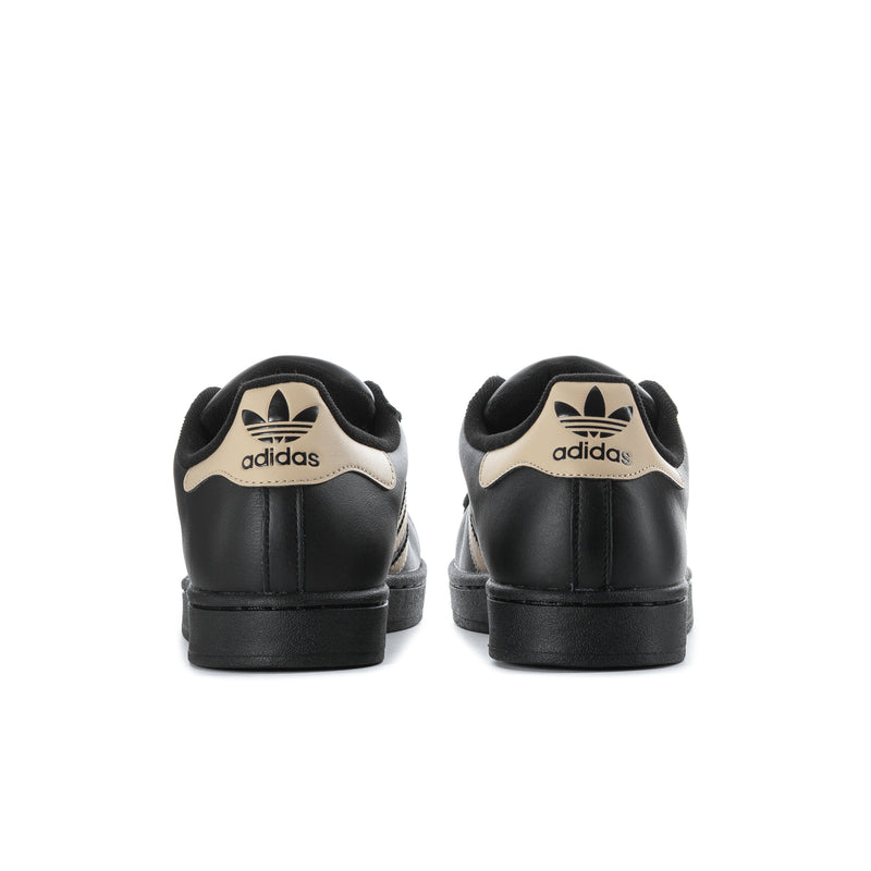 Black adidas sneakers rear view with beige heel tabs and adidas logo.
