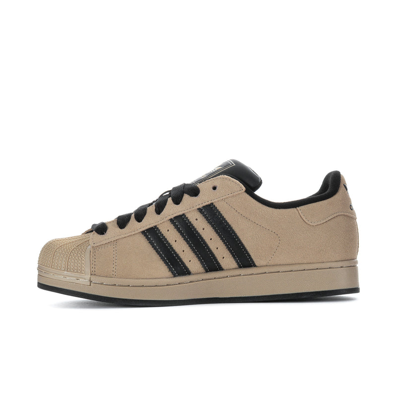 Men's tan sneakers with black laces and navy three-stripe side panels