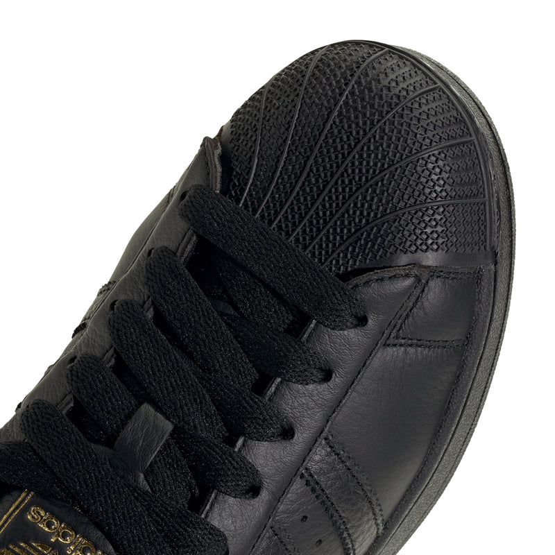 Men's black leather sneaker upper close-up with textured side and lace area.