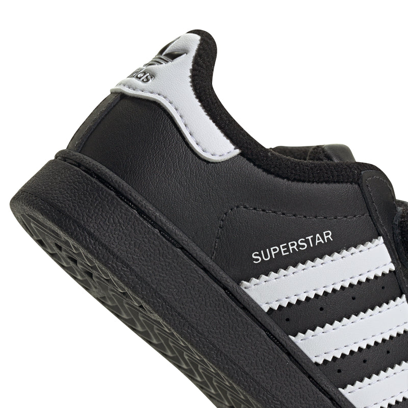 Toddler black sneaker with SUPERSTAR text, white stripes, and Velcro strap