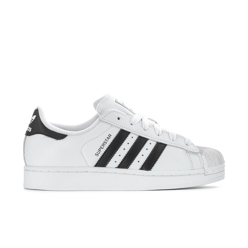 Women's low-top sneakers in white with black three-stripe details, lace-up design