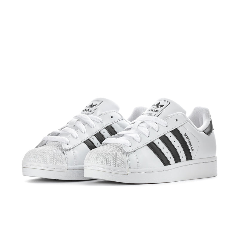 Pair of women's white low-top sneakers with black stripes and white laces