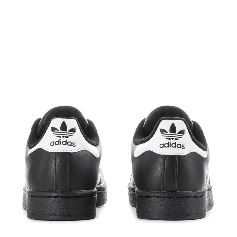 Black low-top lace-up sneakers with adidas trefoil logo on heel and white accents.