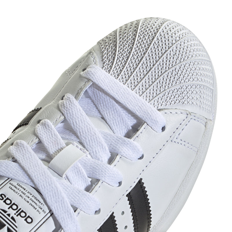Close-up of women's white sneaker upper with white laces and textured side panel