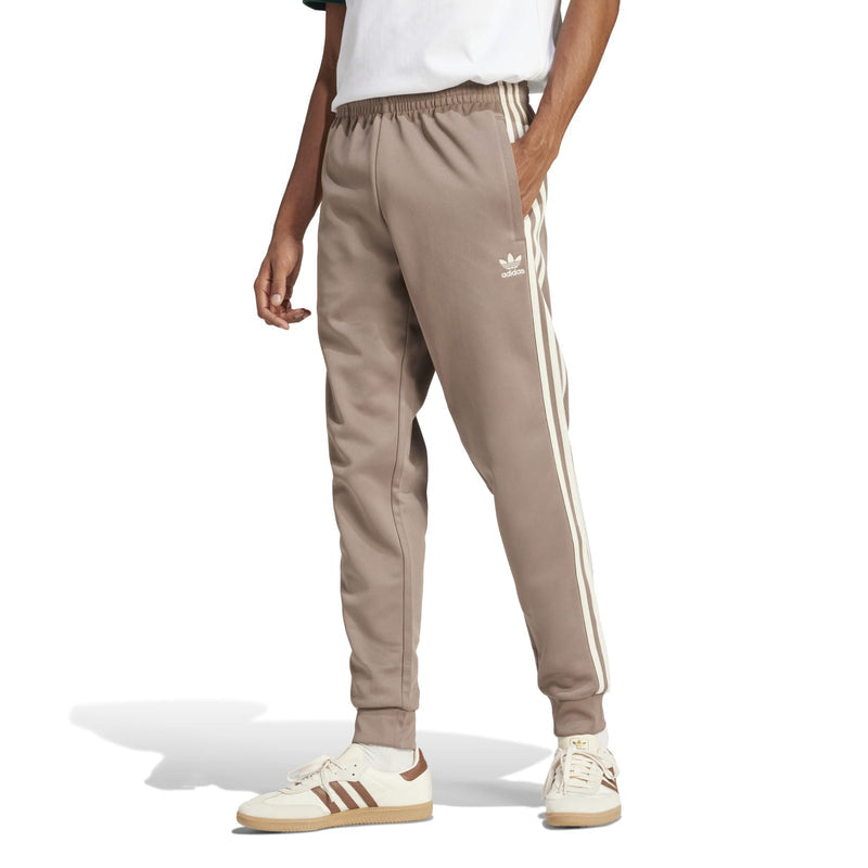 Men's taupe track pants with white side stripes and adidas logo